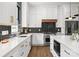 Modern kitchen with black backsplash, stainless steel appliances, quartz countertops and white cabinets with gold hardware accents at 1626 Burtonwood Cir, Charlotte, NC 28212