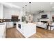 Open-concept kitchen with stainless steel appliances, white cabinetry, quartz countertop island, and view into the connected living space at 1626 Burtonwood Cir, Charlotte, NC 28212