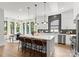 Bright open kitchen featuring a large island with seating, stainless steel appliances, and a modern lighting fixture above the dining area at 1626 Burtonwood Cir, Charlotte, NC 28212