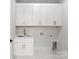 Clean laundry room with white shaker cabinets, gold hardware, and modern tile floors at 1626 Burtonwood Cir, Charlotte, NC 28212