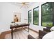 Bright and modern home office space with large windows, hardwood floors, a sleek desk, and comfortable seating at 1626 Burtonwood Cir, Charlotte, NC 28212