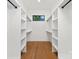 Spacious walk-in closet with custom shelving and hardwood floors at 1626 Burtonwood Cir, Charlotte, NC 28212