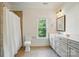 Bright bathroom featuring a shower with neutral tiling, white vanity, and a window with natural light at 167 Logan Crossing Dr, Davidson, NC 28036