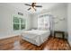 Inviting bedroom with hardwood floors, a ceiling fan, and a cozy bed next to a window with natural light at 167 Logan Crossing Dr, Davidson, NC 28036