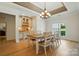 Elegant dining room featuring a stylish chandelier, hardwood floors, and seamless transition to the kitchen and outdoor views at 167 Logan Crossing Dr, Davidson, NC 28036