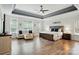 A luxurious main bedroom offers a tray ceiling, a cozy seating area, and large windows for natural light at 167 Logan Crossing Dr, Davidson, NC 28036