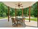 Covered patio with ceiling fan and a table and chairs overlooking the swimming pool and wooded backyard at 167 Logan Crossing Dr, Davidson, NC 28036