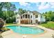 Backyard view showcases a beautiful in-ground pool, patio area, and well-maintained white brick home at 167 Logan Crossing Dr, Davidson, NC 28036