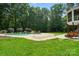 Lush backyard featuring an in-ground pool with a waterfall feature, mature trees and patio area at 167 Logan Crossing Dr, Davidson, NC 28036