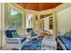 Inviting screened-in porch with comfortable wicker furniture and a bright blue pineapple-themed rug at 167 Logan Crossing Dr, Davidson, NC 28036