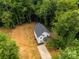 Aerial view of a two-story home with a gray roof surrounded by dense green trees at 1723 Rhyneland Cir, Gastonia, NC 28054