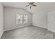 A bedroom with a ceiling fan, two windows, neutral walls and light grey flooring at 1723 Rhyneland Cir, Gastonia, NC 28054
