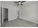 A bedroom with a ceiling fan, neutral walls, light grey flooring and access to an adjoined closet at 1723 Rhyneland Cir, Gastonia, NC 28054