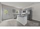 Modern kitchen with gray cabinets, stainless steel appliances, island, and gray wood-look floors at 1723 Rhyneland Cir, Gastonia, NC 28054