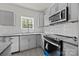 Modern kitchen with gray cabinets, stainless steel appliances, granite counters, and white subway tile backsplash at 1723 Rhyneland Cir, Gastonia, NC 28054