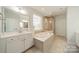 Relaxing bathroom equipped with a soaking tub, walk-in shower, double vanity, and tiled floors at 1812 Sutter Creek Dr, Waxhaw, NC 28173