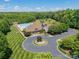 View of a community clubhouse surrounded by lush greenery with a circular driveway and ample parking at 1812 Sutter Creek Dr, Waxhaw, NC 28173
