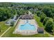 Aerial view of a large community pool with plenty of lounge chairs surrounded by green lawns and trees at 1812 Sutter Creek Dr, Waxhaw, NC 28173