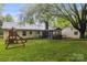Large backyard features a screened-in porch, playset, and beautiful mature trees at 1821 Bonnie Ln, Charlotte, NC 28213