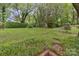 Serene backyard featuring lush greenery, a mature trees, and a brick-lined garden bed at 1821 Bonnie Ln, Charlotte, NC 28213