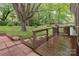 Private backyard with mature trees, deck, and brick patio, perfect for outdoor entertaining at 1821 Bonnie Ln, Charlotte, NC 28213