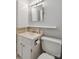 Bright bathroom with a white vanity, toilet, medicine cabinet, shelf, and modern lighting at 1821 Bonnie Ln, Charlotte, NC 28213