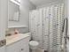 Neutral bathroom featuring a white vanity, toilet, mirror, and fish-themed shower curtain at 1821 Bonnie Ln, Charlotte, NC 28213