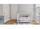 Bright Bedroom features a crib, dresser, two windows, and hardwood floors, perfect for a cozy atmosphere at 1821 Bonnie Ln, Charlotte, NC 28213