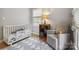 Comfortable Bedroom includes a crib, a glider, a patterned rug, and natural light from a window at 1821 Bonnie Ln, Charlotte, NC 28213