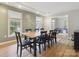 Spacious dining room with wood floors, large table, and ample natural light from windows with a view of the bonus room at 1821 Bonnie Ln, Charlotte, NC 28213