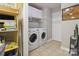 Efficient laundry room featuring a washer, dryer, overhead cabinets, and tiled floor at 1821 Bonnie Ln, Charlotte, NC 28213