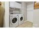 Functional laundry room with washer, dryer, overhead storage cabinets, and a tidy design at 1821 Bonnie Ln, Charlotte, NC 28213