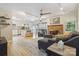 Open concept living room with a brick fireplace, hardwood floors, and modern furnishings at 1821 Bonnie Ln, Charlotte, NC 28213
