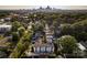 Aerial view of a quiet, tree-lined neighborhood with modern townhouses and the city skyline in the distance at 2011 Hamorton Pl, Charlotte, NC 28205