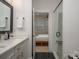 Stylish bathroom featuring double sinks, a glass-enclosed shower, and a view into the bedroom at 2011 Hamorton Pl, Charlotte, NC 28205