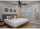 Bright bedroom features a ceiling fan, a bed with colorful pillows, and two windows providing natural light at 2011 Hamorton Pl, Charlotte, NC 28205