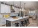 Bright kitchen features a large island with stools, white cabinetry, stainless steel appliances, and open floorplan at 2011 Hamorton Pl, Charlotte, NC 28205