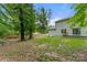 Backyard with a lush lawn, privacy fence, mature trees, and a partial view of the house at 2025 Slater Rd, Charlotte, NC 28216