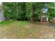 Large, private backyard with a storage shed and a lush tree line at 2025 Slater Rd, Charlotte, NC 28216