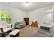 Well-lit bedroom with carpeting, a comfy rocking chair, and a dresser at 2025 Slater Rd, Charlotte, NC 28216