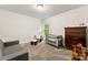 Bright bedroom featuring neutral walls, plush carpeting, and a comfortable seating area, and dark wood dresser at 2025 Slater Rd, Charlotte, NC 28216
