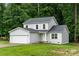 Charming two-story home with a gray exterior, attached garage, and lush green lawn at 2025 Slater Rd, Charlotte, NC 28216