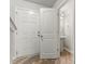 Hallway view of a door to a bathroom with a pedestal sink and an open doorway at 2025 Slater Rd, Charlotte, NC 28216