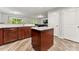 Bright eat-in kitchen with wood floors, granite countertops, stainless steel appliances, and a kitchen island at 2025 Slater Rd, Charlotte, NC 28216
