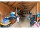 Interior view of a storage shed with exposed rafters, organized storage, and concrete floor at 2025 Slater Rd, Charlotte, NC 28216