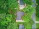 A bird's eye view shows a home nestled among lush green trees with plenty of yard space and nearby streets at 2026 Knell Dr, Charlotte, NC 28212