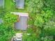 A bird's eye view shows a home nestled among lush green trees with plenty of yard space and nearby homes at 2026 Knell Dr, Charlotte, NC 28212