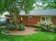 Spacious backyard featuring a brick house, green grass, and a patio area at 2026 Knell Dr, Charlotte, NC 28212