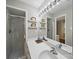 Bathroom featuring a white sink, framed mirror, stand alone shower with glass door, and bright natural lighting at 2026 Knell Dr, Charlotte, NC 28212