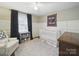 Bedroom showcases white crib, decorative quilt, gray leopard carpet, and neutral walls at 2026 Knell Dr, Charlotte, NC 28212